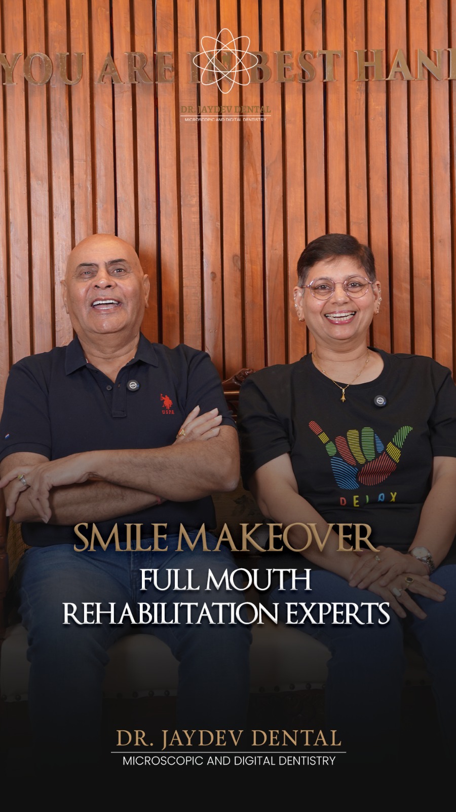 Two smiling adults sit together in a dental clinic backdrop with wooden panels and the words 'Smile Makeover' and 'Full Mouth Rehabilitation Experts' overlay text at the bottom.